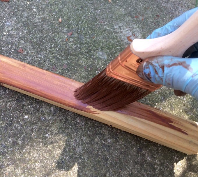 Staining 2 x 2s with a brush wearing gloves