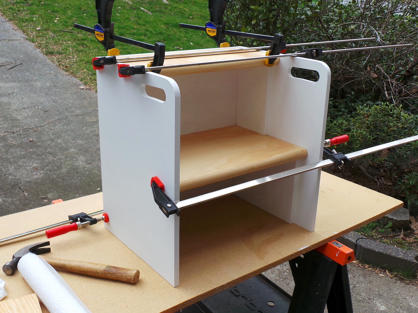 Finished DIY wood step stool being held together with clamps to dry