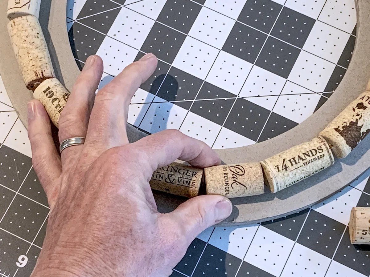 Hand gluing corks around a wreath ring