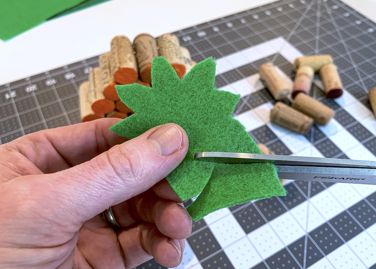 Cutting pumpkin stems out of green felt iwth scissors