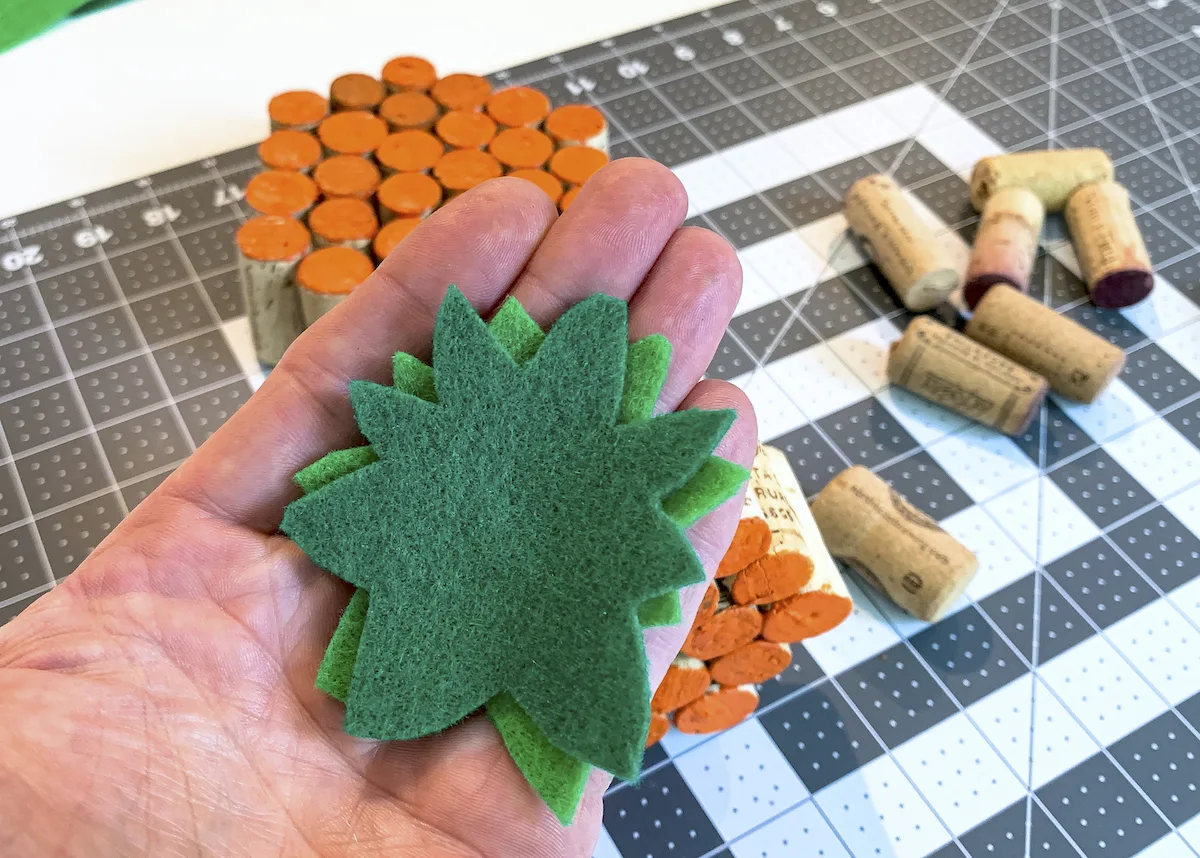 Green felt stems cut out and sitting in a man's hand