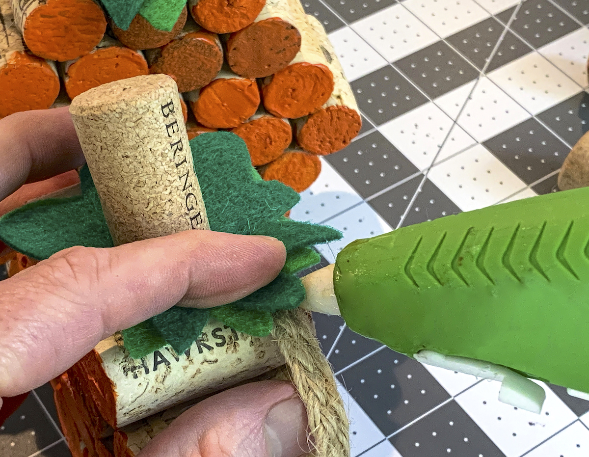 Hot gluing burlap ribbon underneath green felt stems