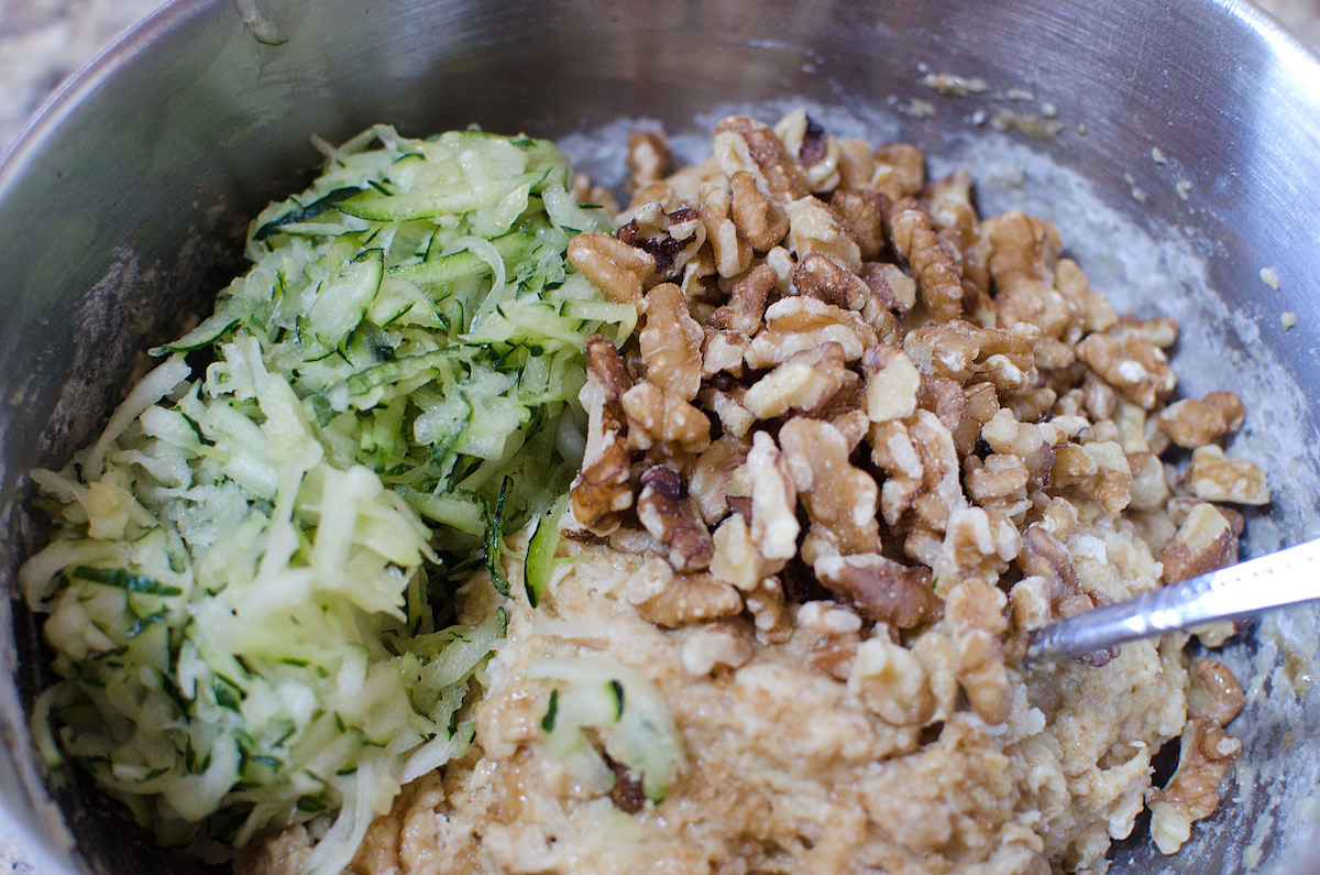 Bowl with zucchini bread batter zucchini and walnuts