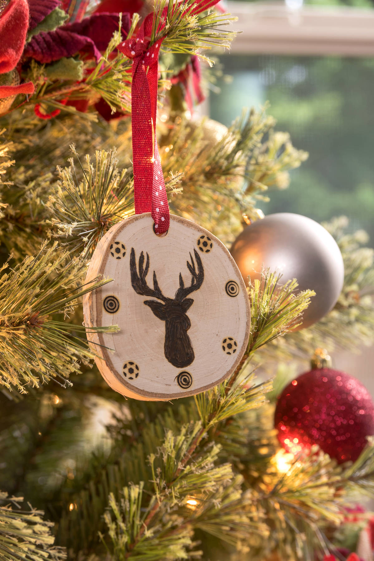 Deer head wood slice ornament on a Christmas tree