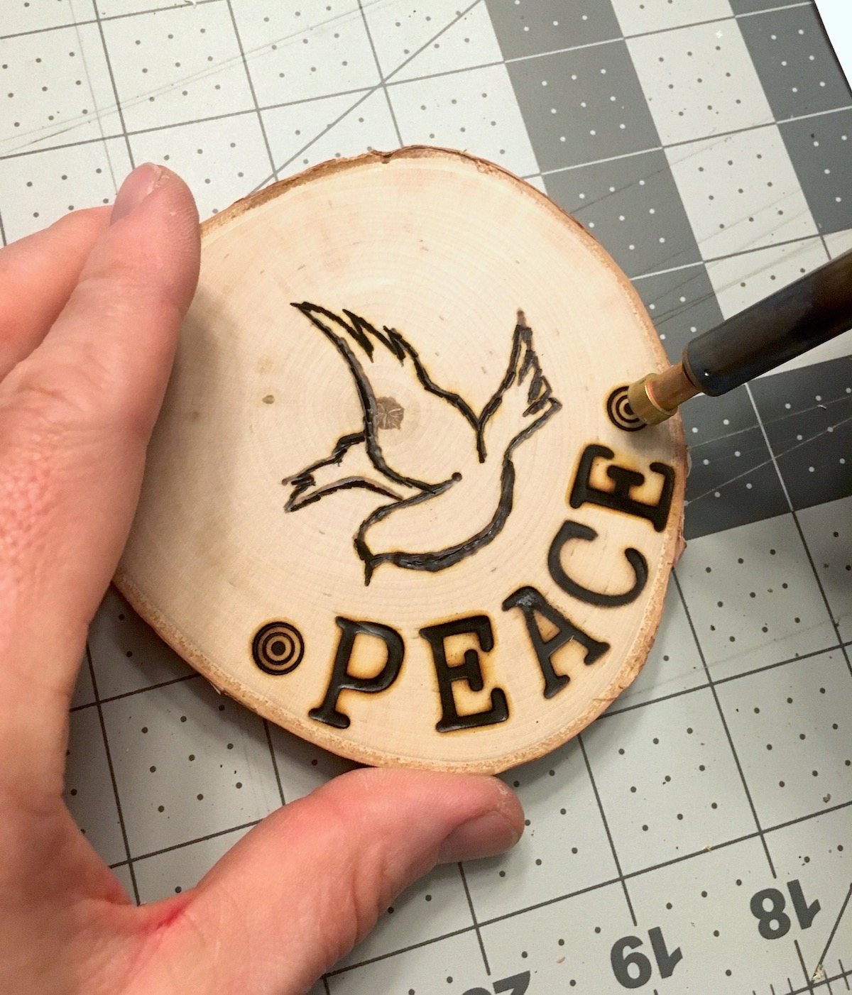 Using a wood burning tool on a wood slice
