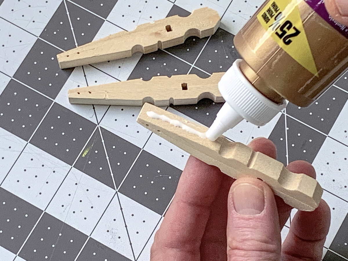 Adding glue to one side of a clothespin