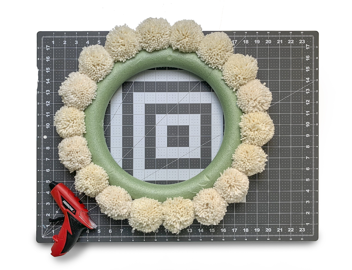 First ring of pom poms around a wreath form