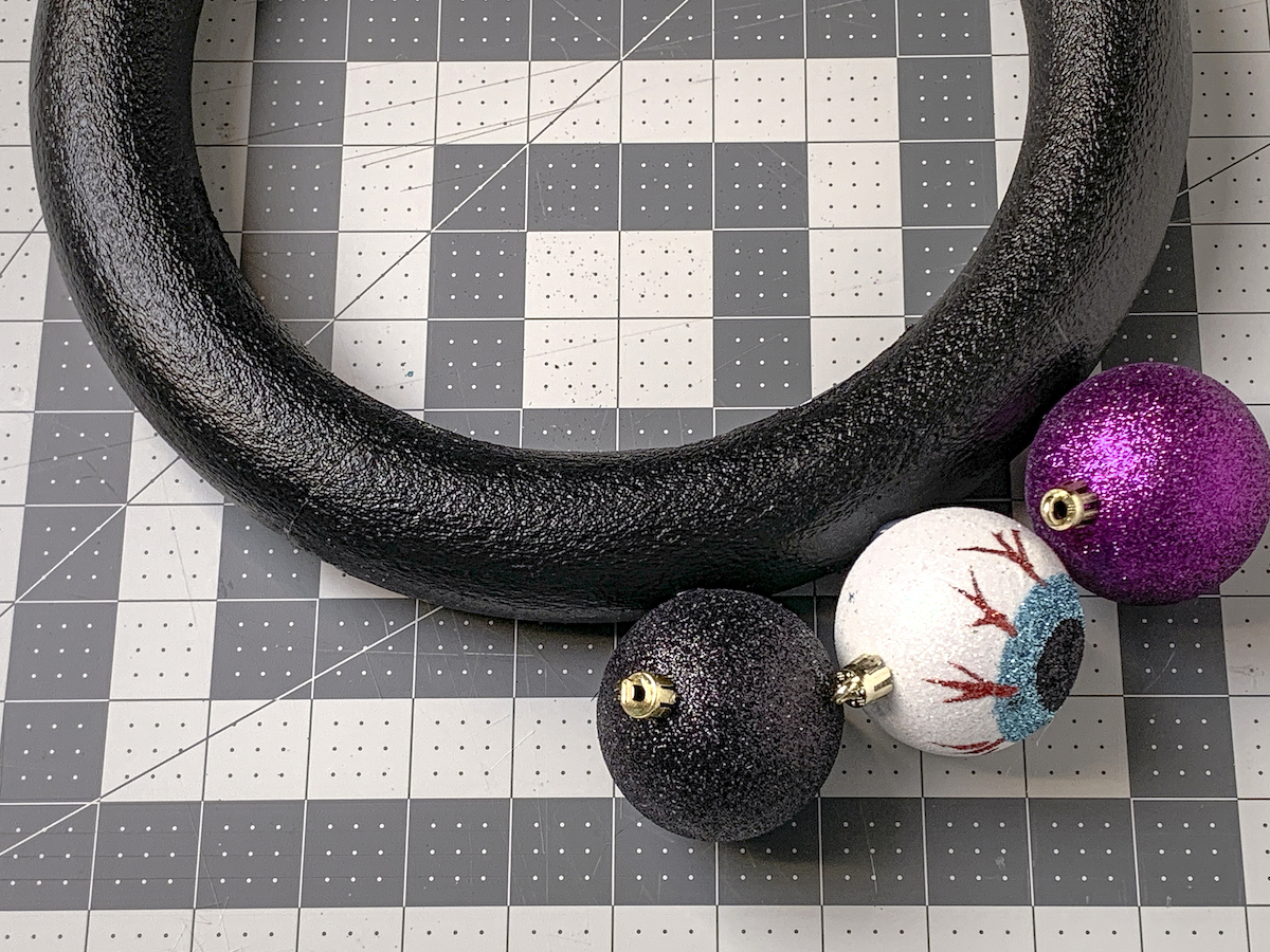 Halloween ornaments glued to the edge of a wreath form
