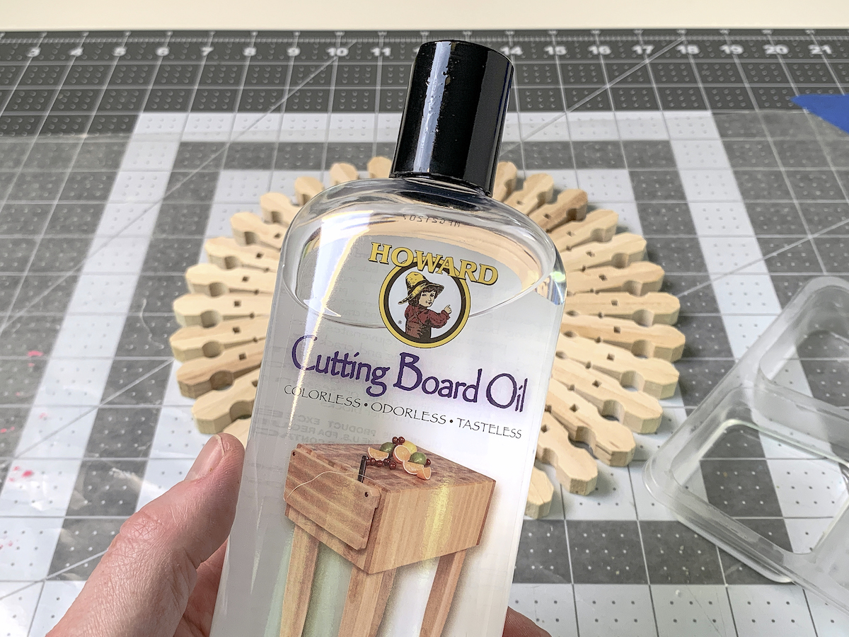 Hand holding a bottle of Howard cutting board oil