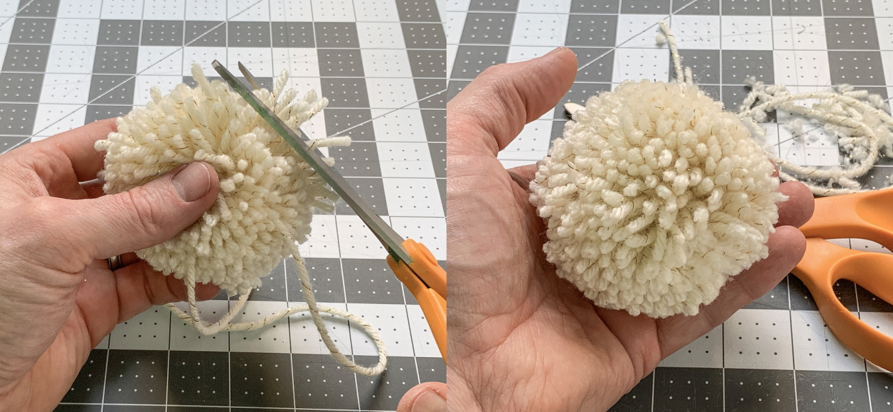 Trimming a finished pom pom with scissors