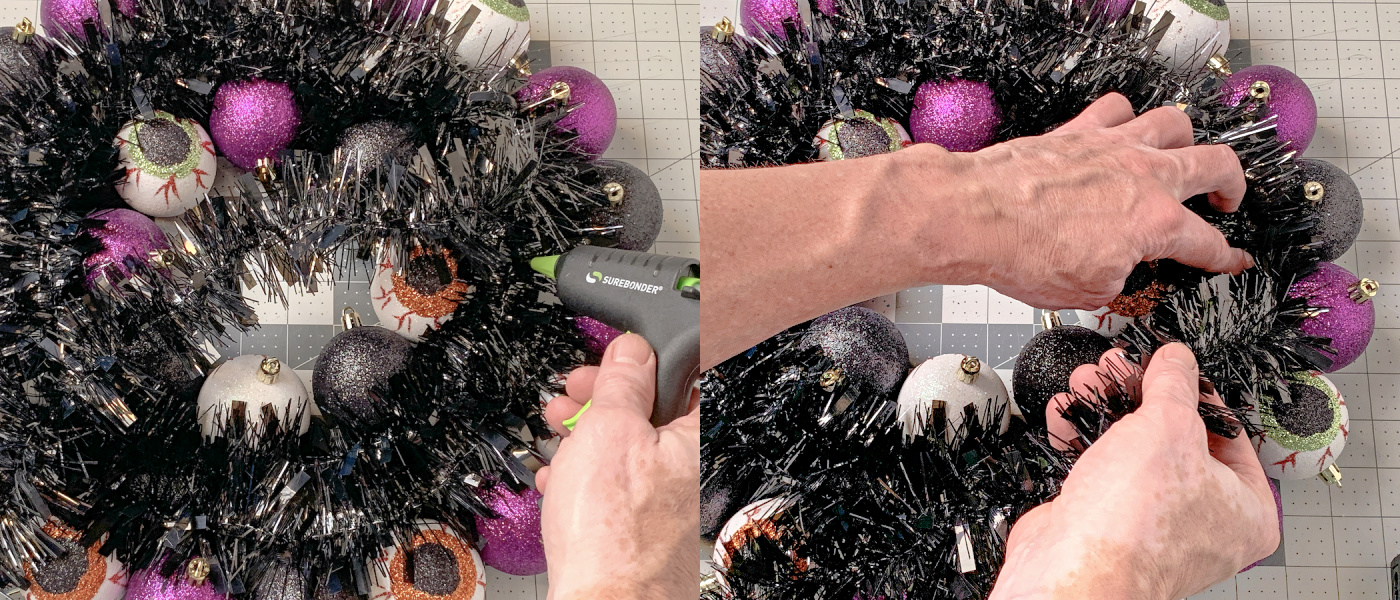 Using hot glue to attach additional black garland
