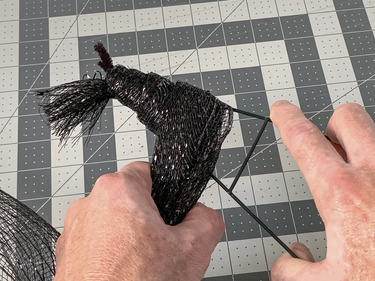 Wrapping deco mesh around the top of the witch hat wreath form