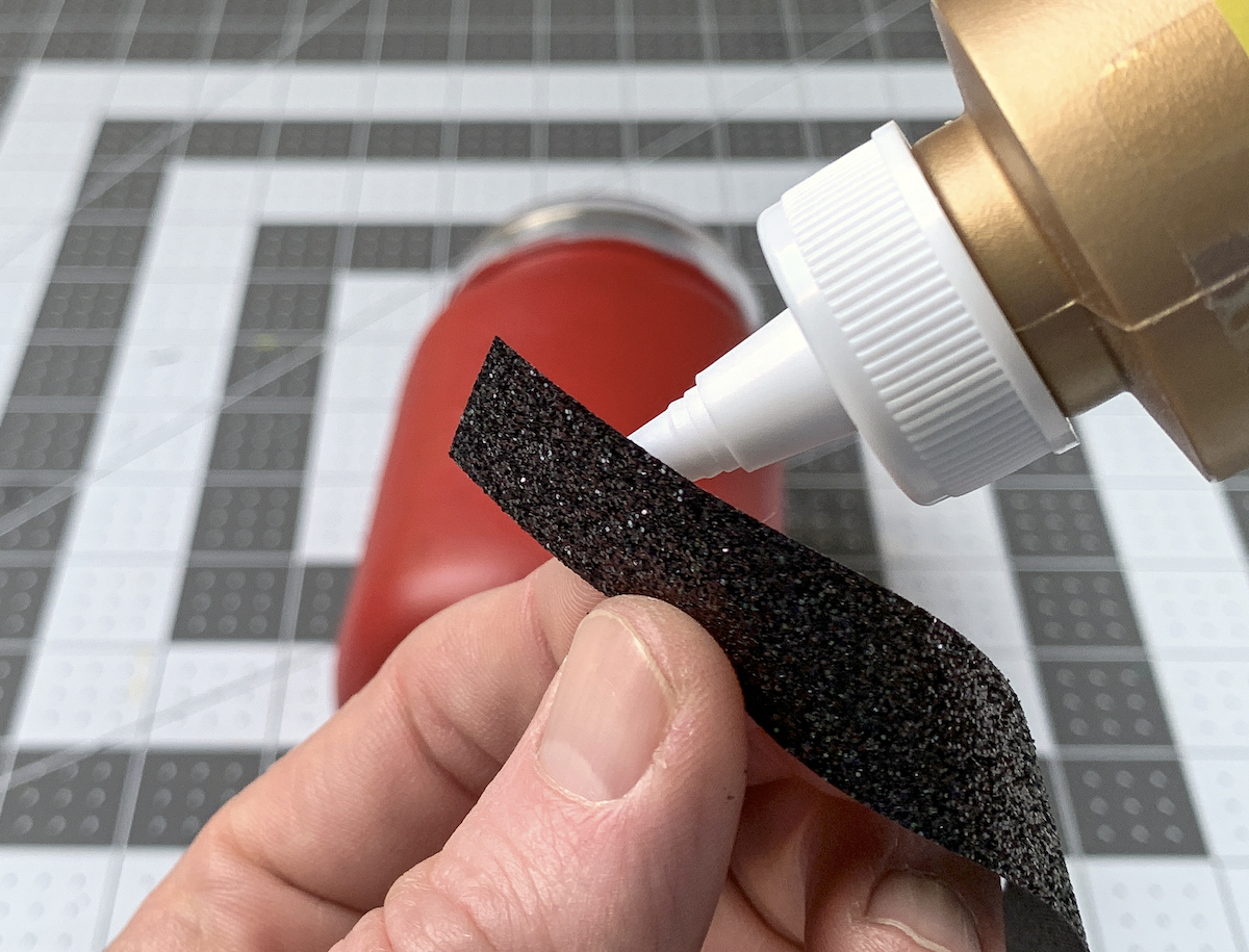 Adding craft glue to the back of black ribbon