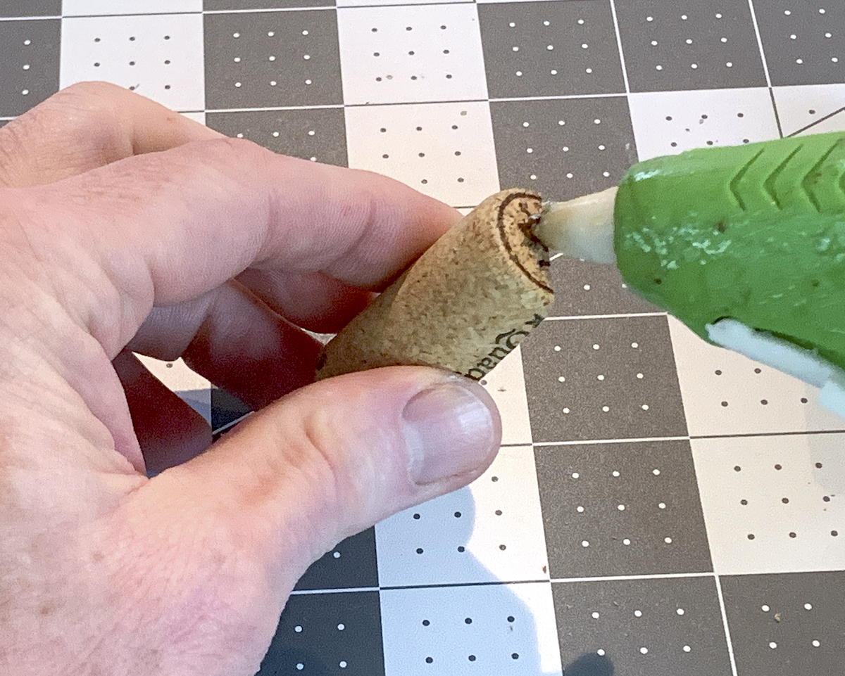 Adding hot glue to the end of a cork half