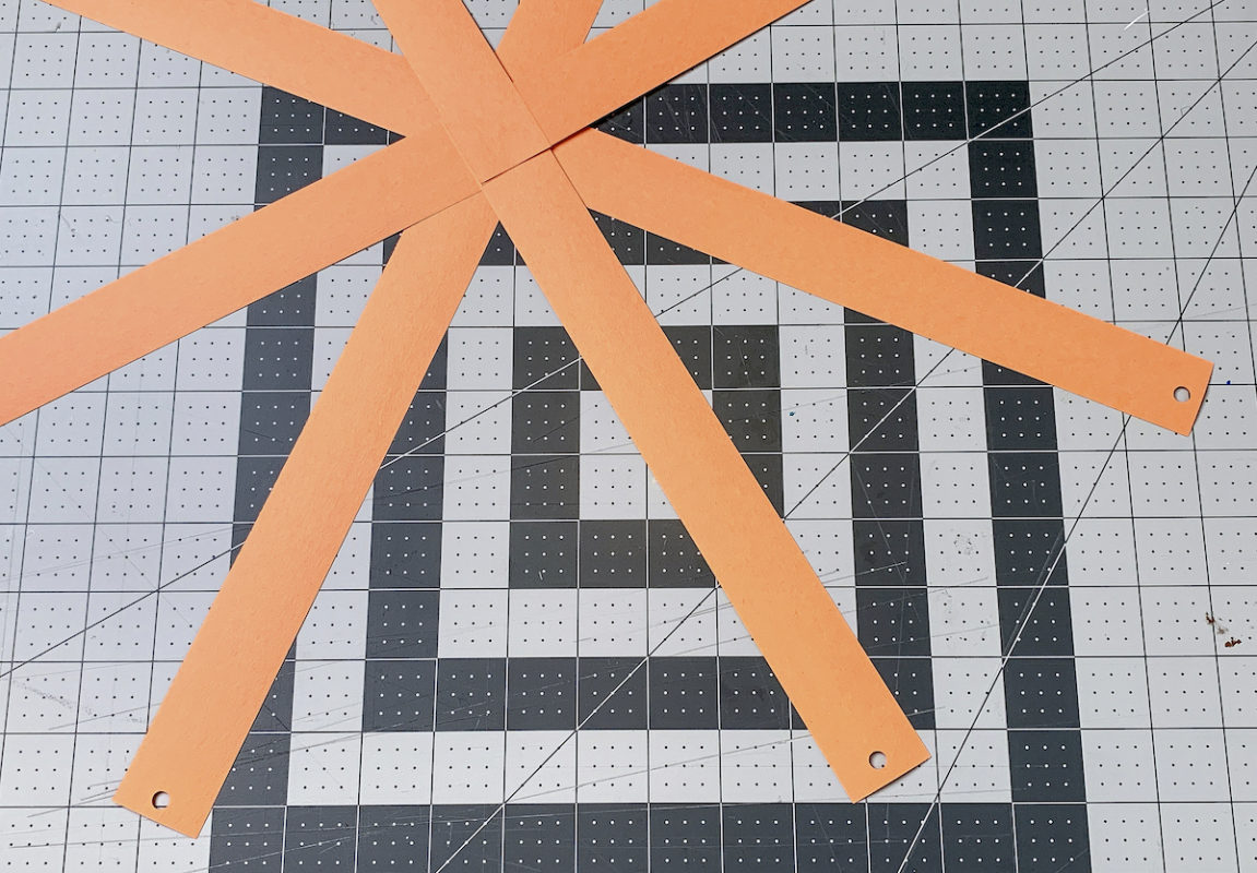 Construction paper strips with holes punched in the end