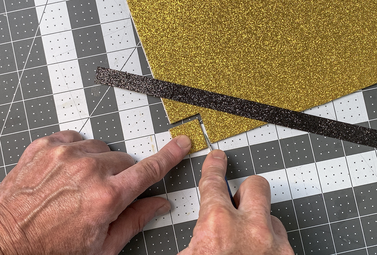 Cutting a square out of gold foam for a buckle