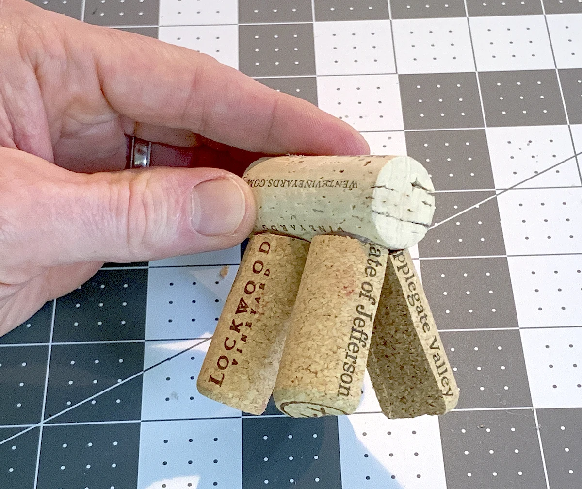 Gluing half wine corks to the bottom of a wine cork as legs