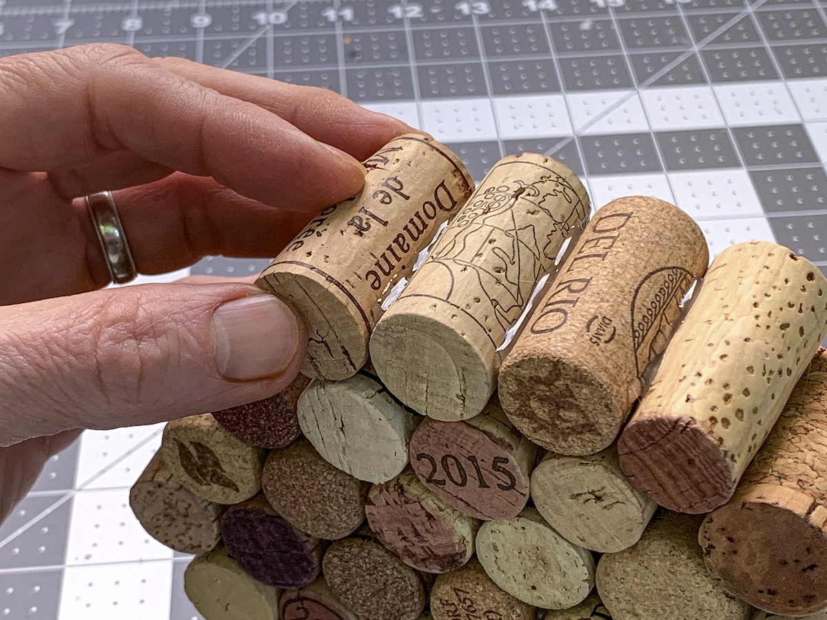 Gluing the final wine cork on a stack of wine corks