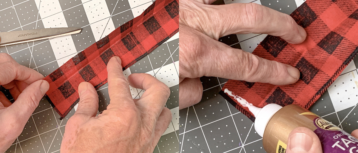 Hand folding the buffalo plaid bandana in half and gluing with craft glue