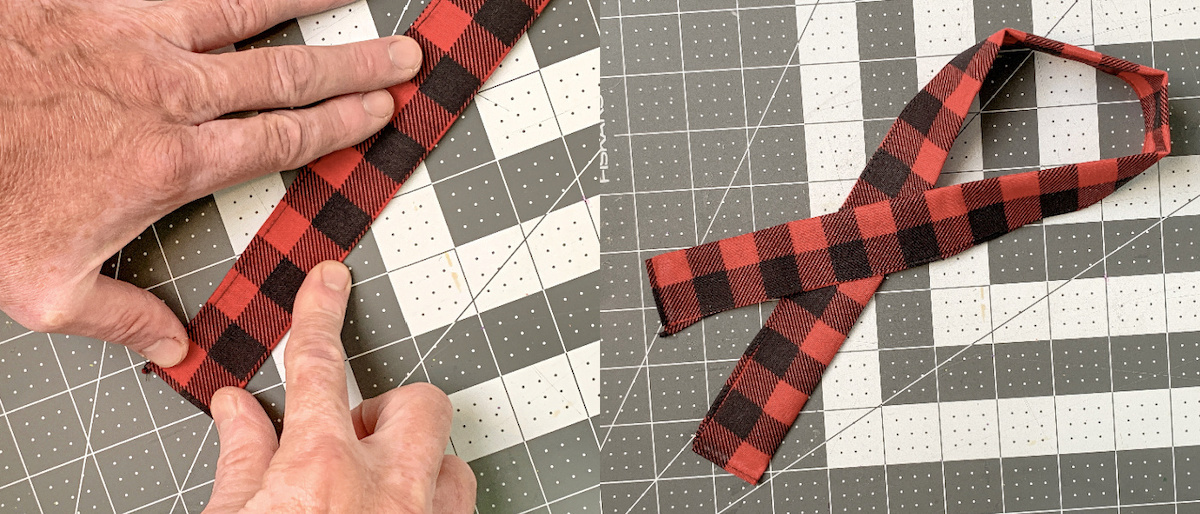 Hand folding the plaid bandana in half