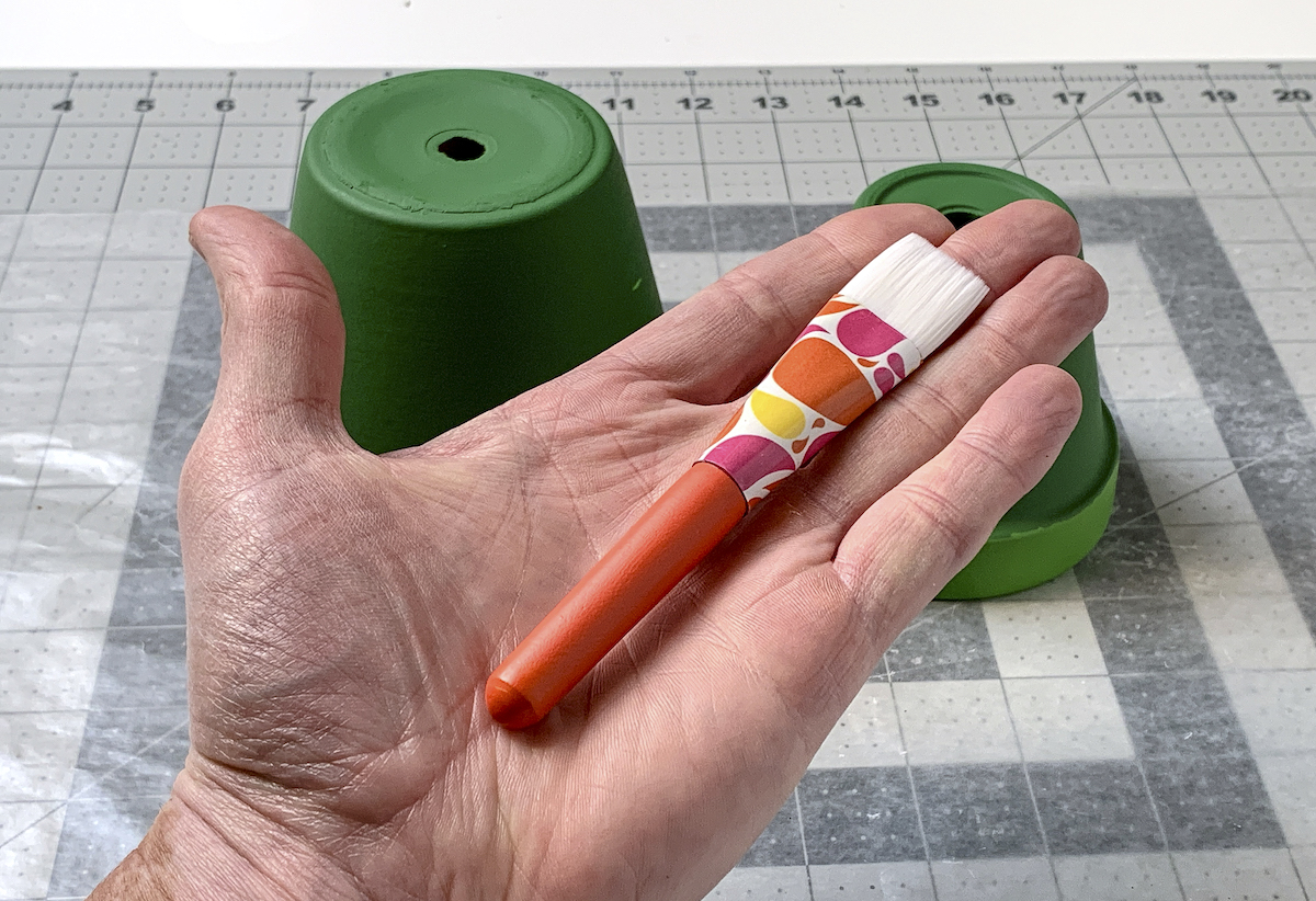 Hand holding a Mod Podge paintbrush