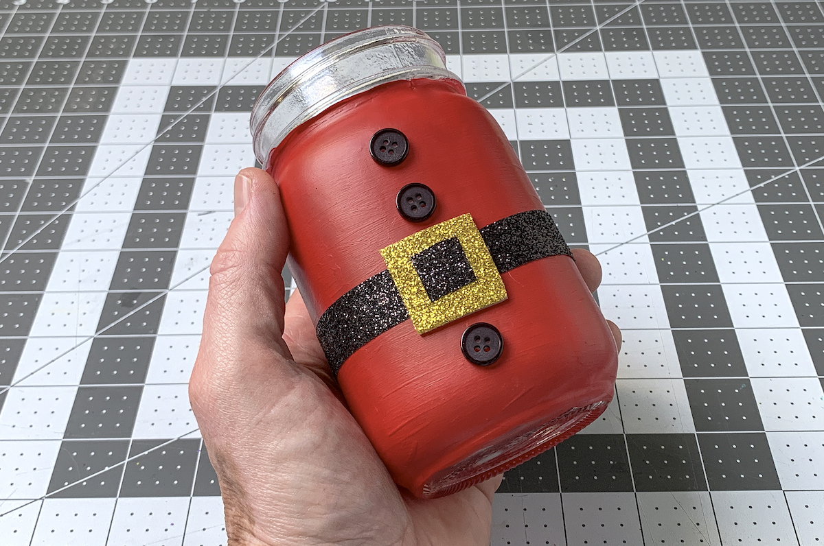 Hand holding the finished Santa mason jar
