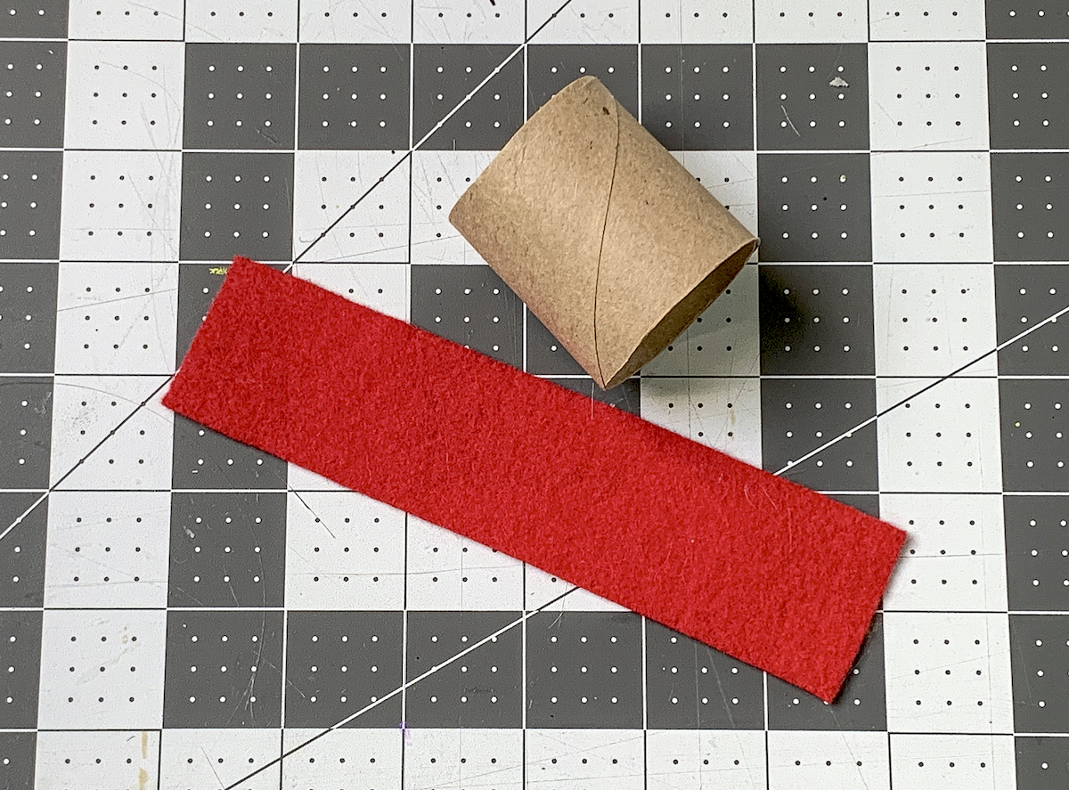 Red strip felt laying next to half a toilet paper roll