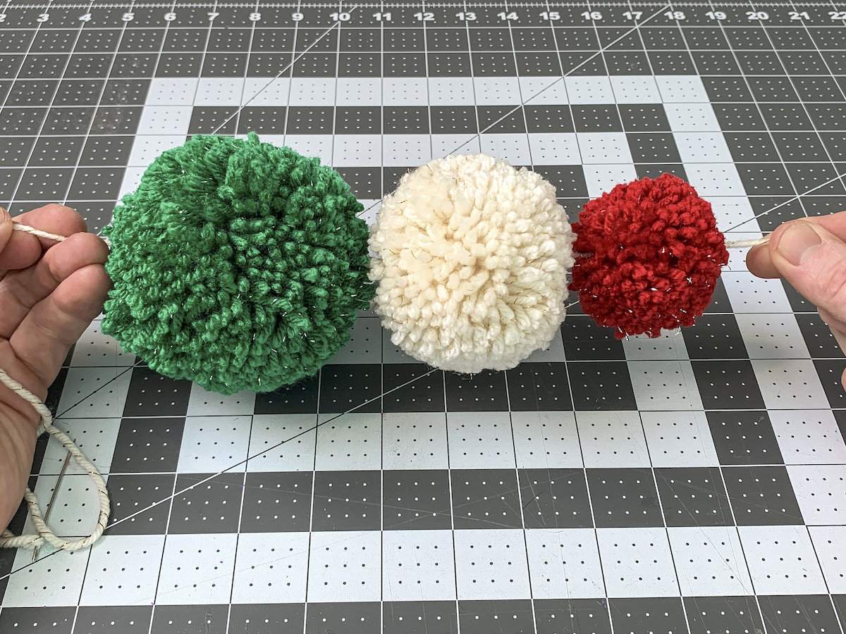 Starting a pom pom garland on a yarn string