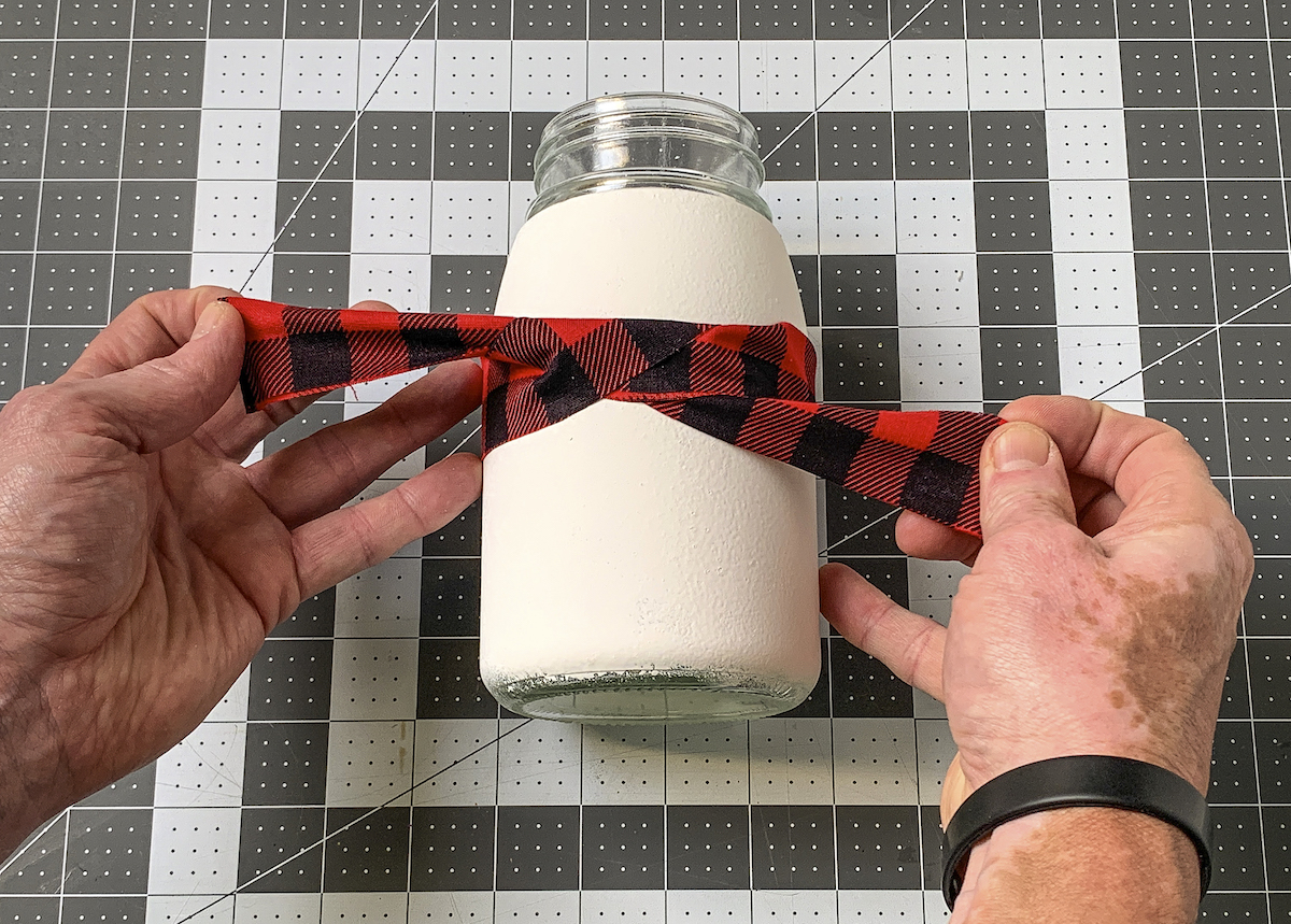 Tying the bandana piece around the center of the jar