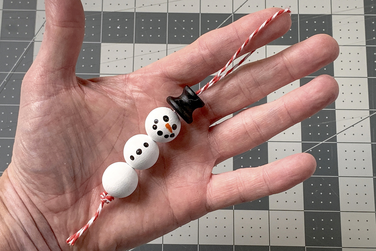 Thread strung through the beaded snowman ornament