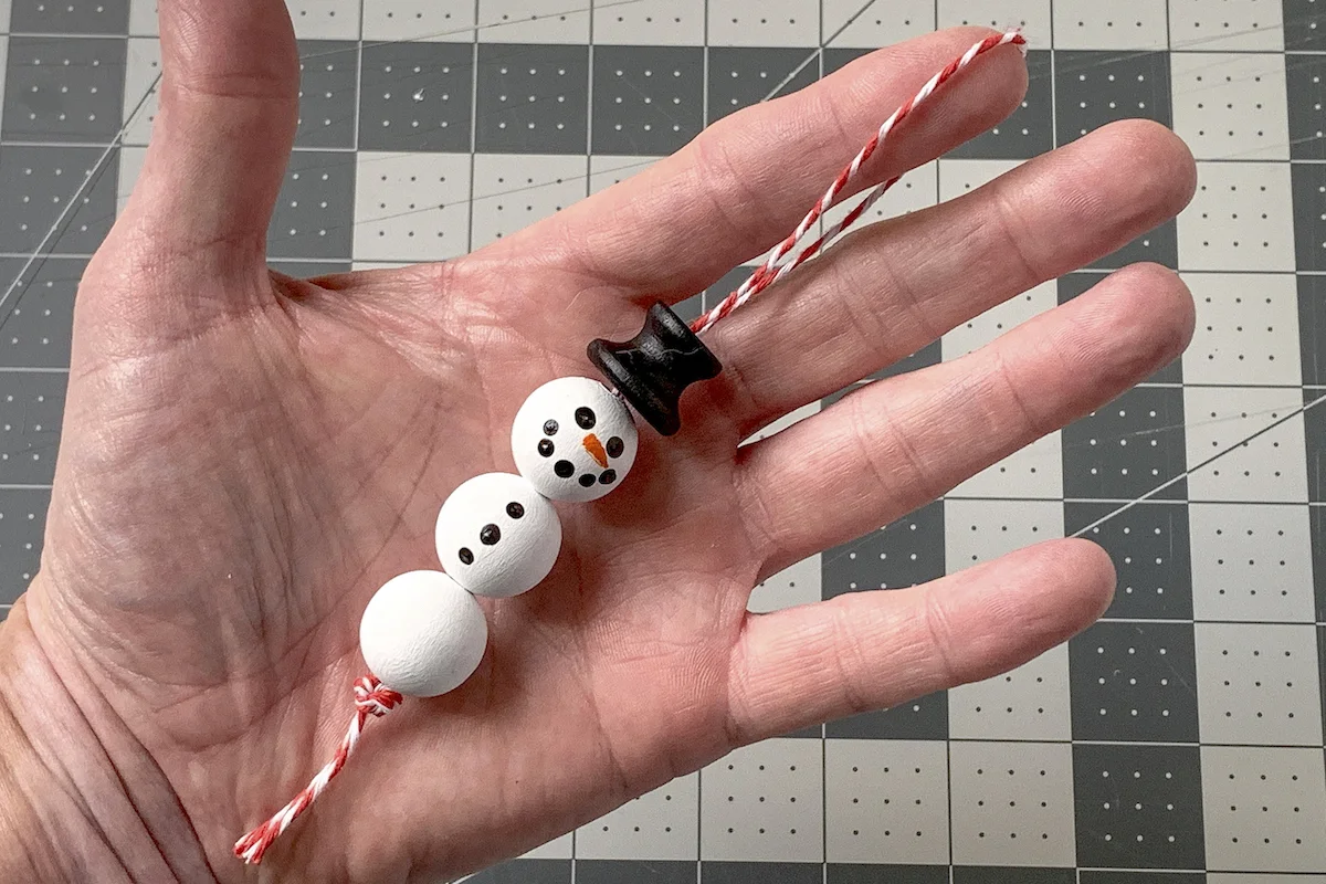 Thread strung through the beaded snowman ornament