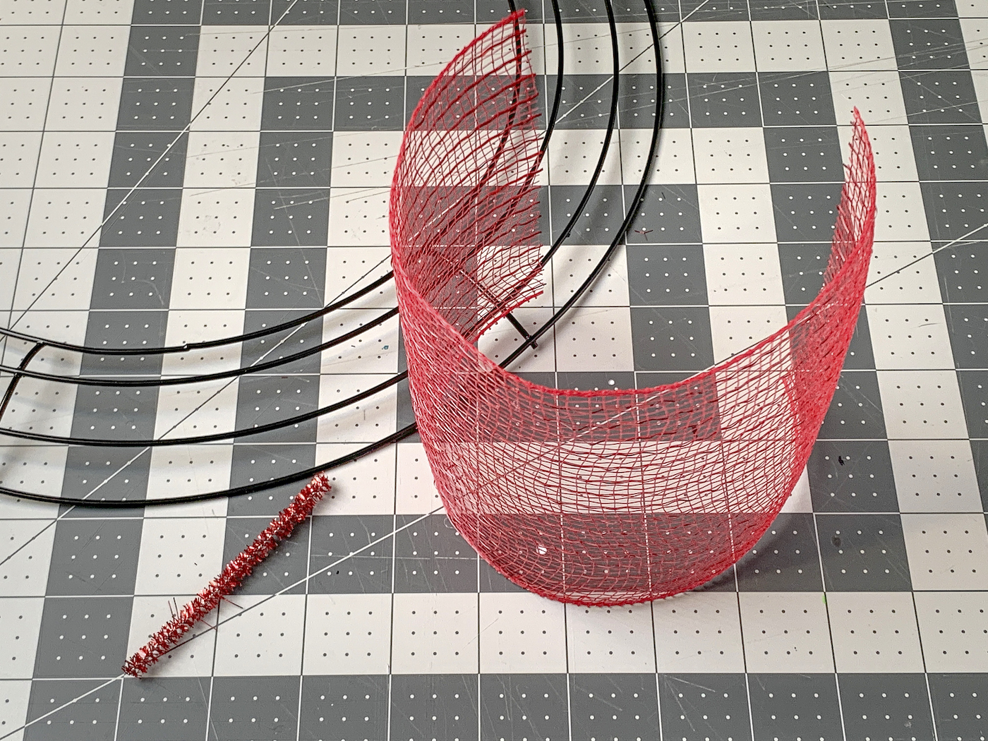 Circle wire wreath form, piece of red deco mesh, and a pipe cleaner piece
