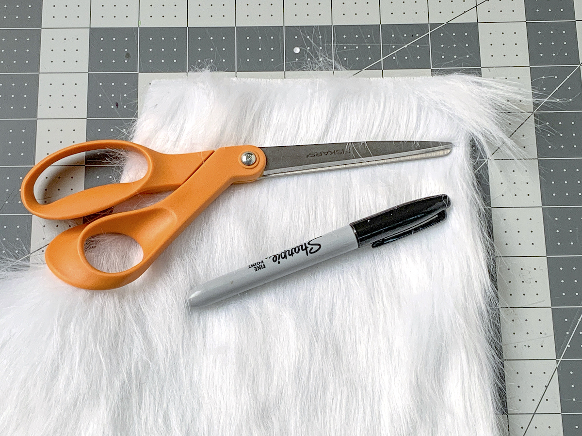 Faux fur, orange handled scissors, and a Sharpie