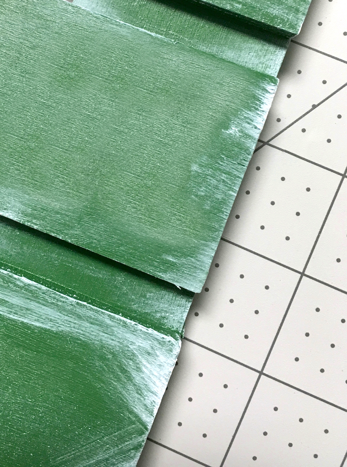 Distressing the edge of the green pallet with white paint