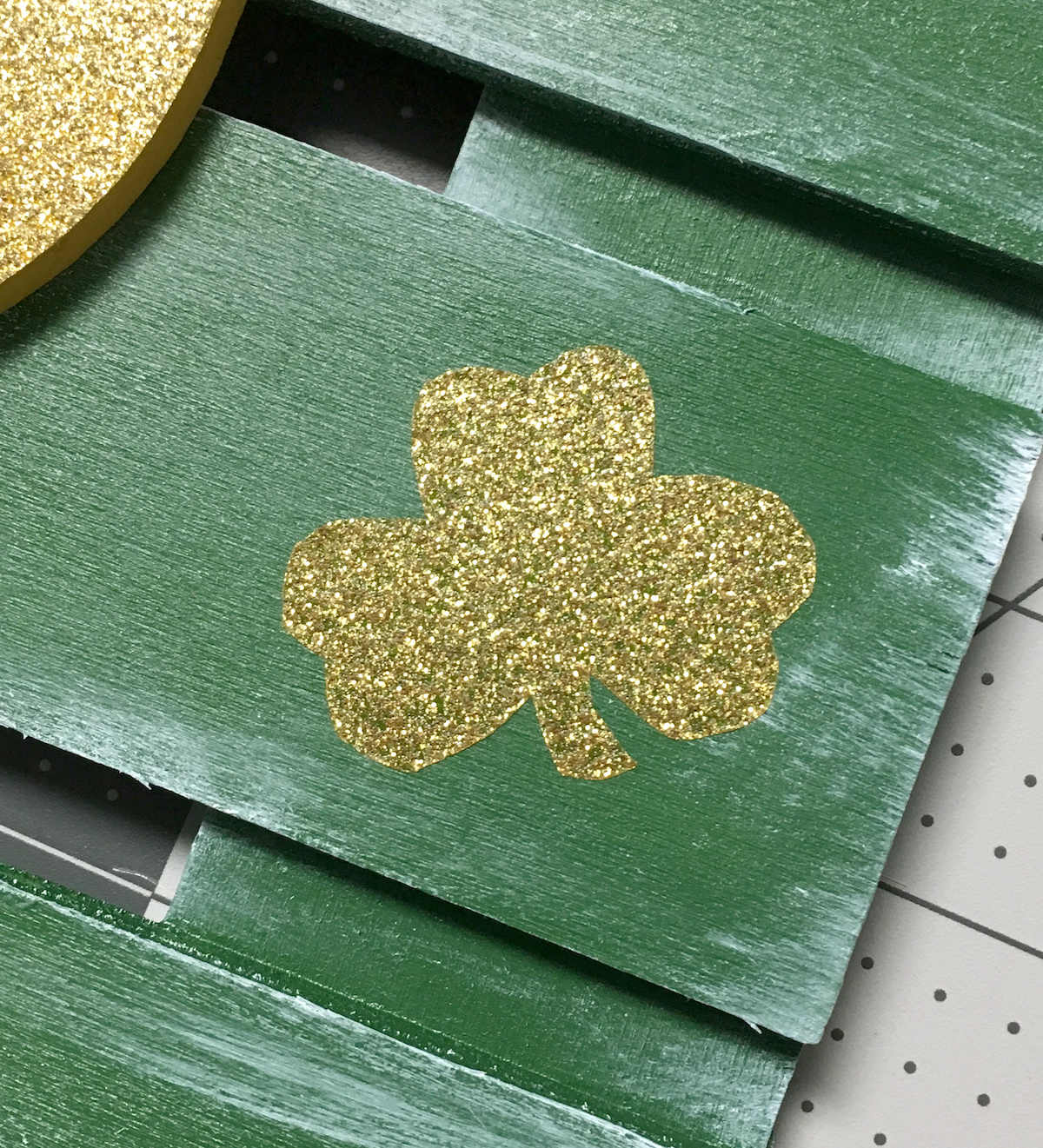 Small gold shamrock on a painted green wood pallet