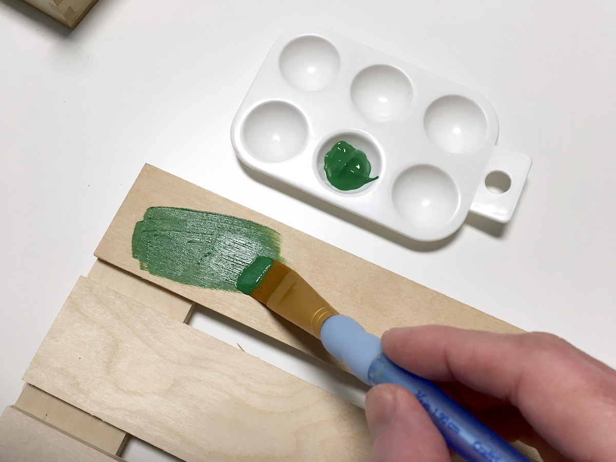 Painting a wood pallet with green paint