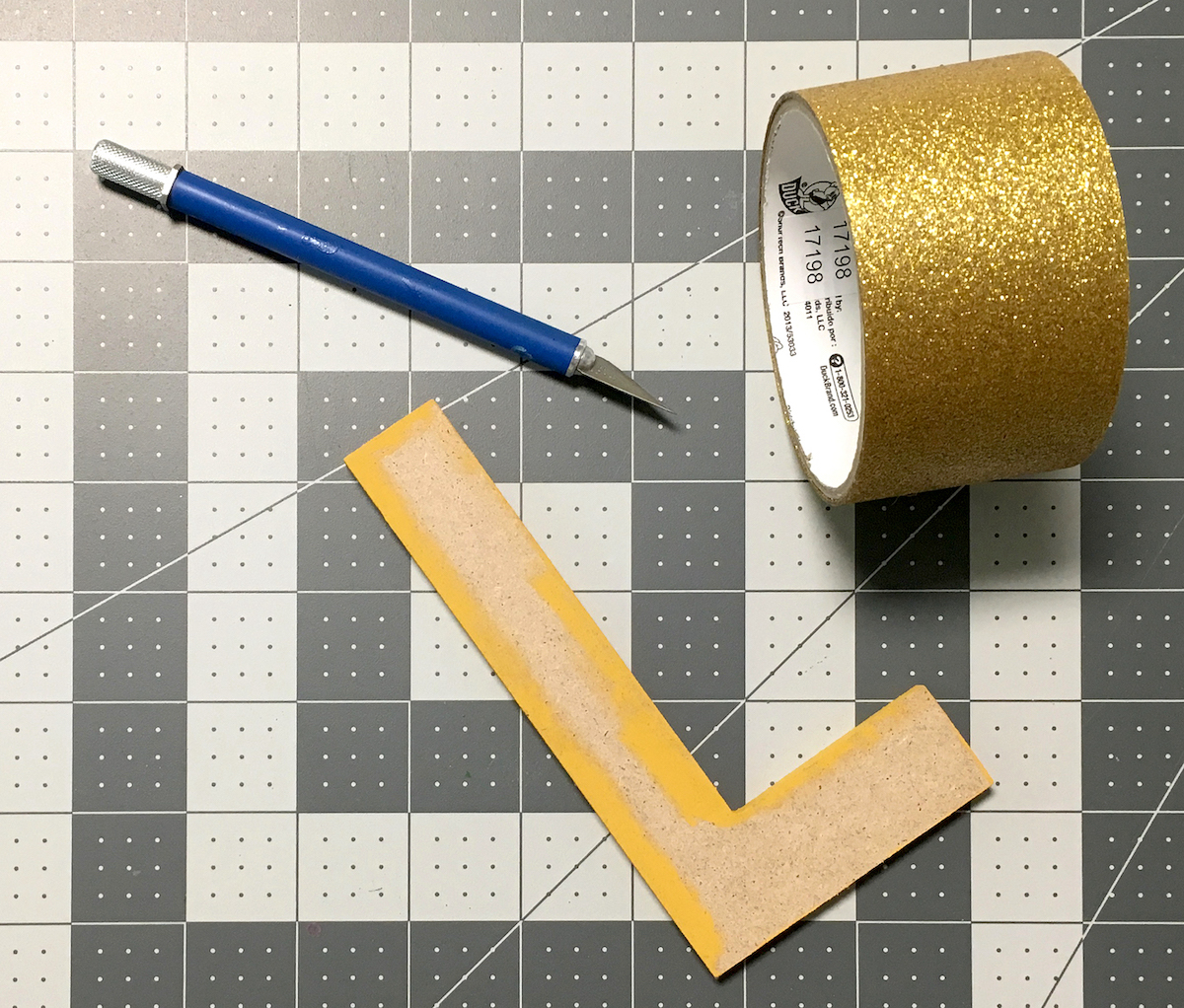 Painted wood letter, Gold Duck Tape, and a craft knife