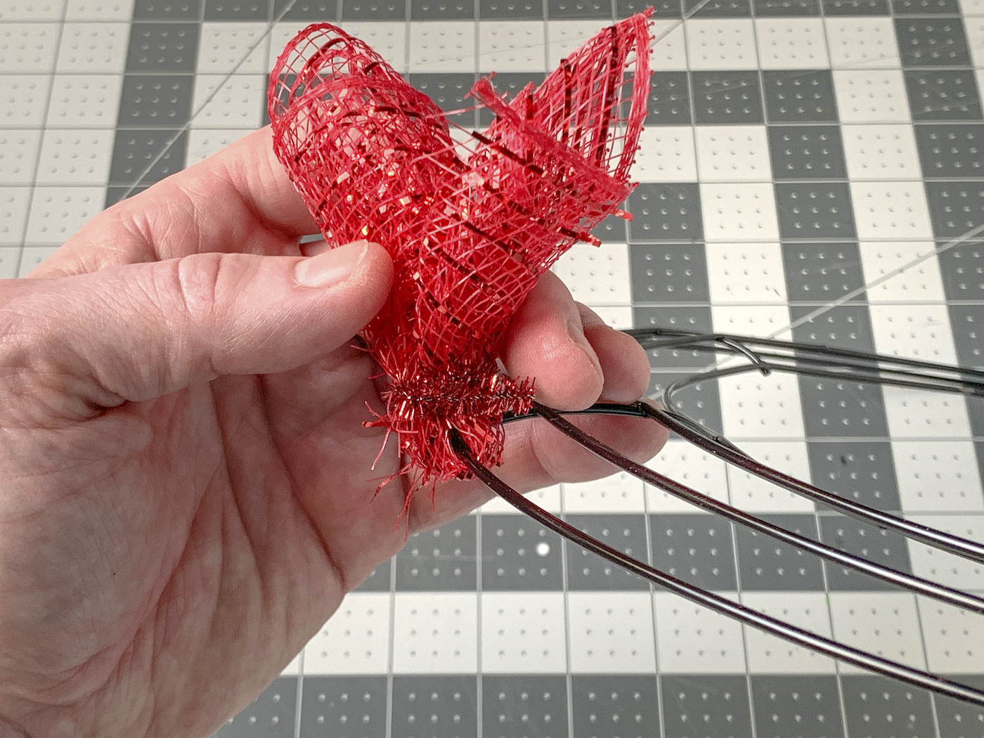 Piece of deco mesh wrapped around the wreath wire and secured with a pipe cleaner