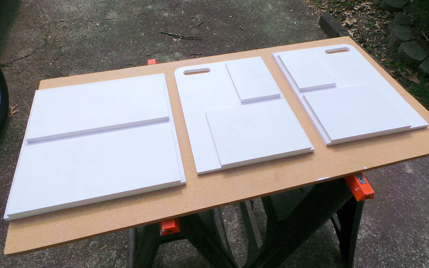 Painted white pieces of MDF laying on a work bench