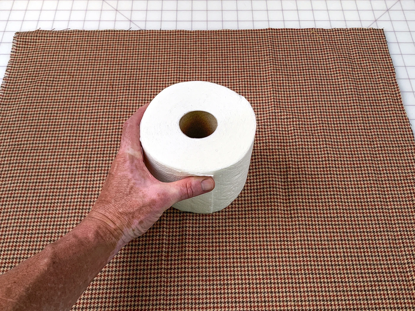 Roll of toilet paper sitting in the center of a piece of fabric