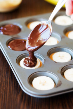 pouring chocolate over the top of the bananas