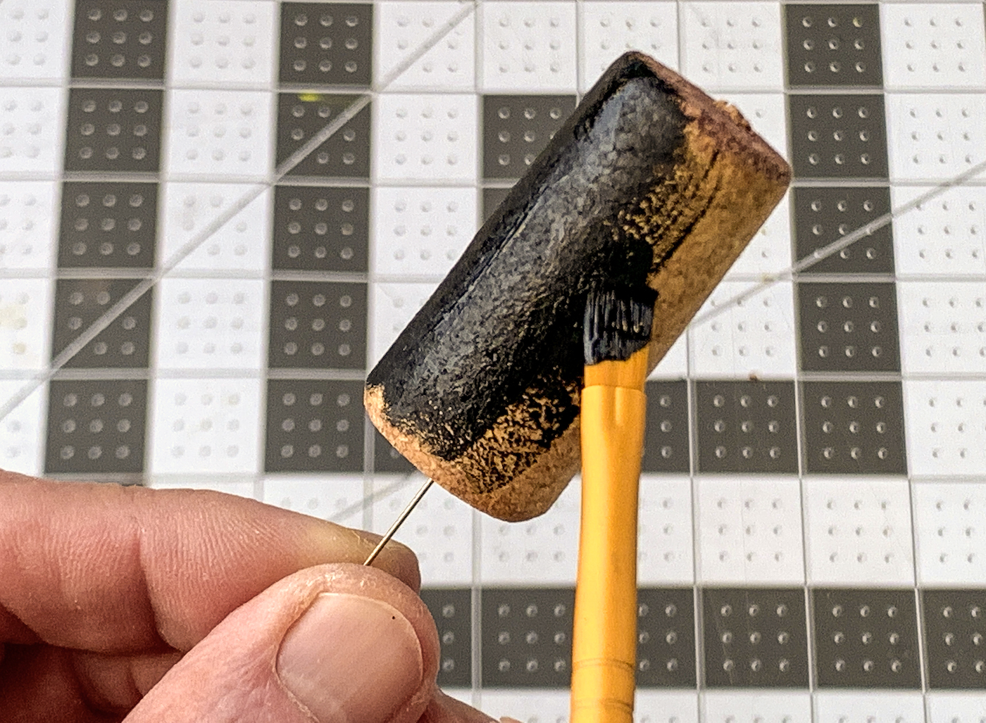 Painting a wine cork with black acrylic paint