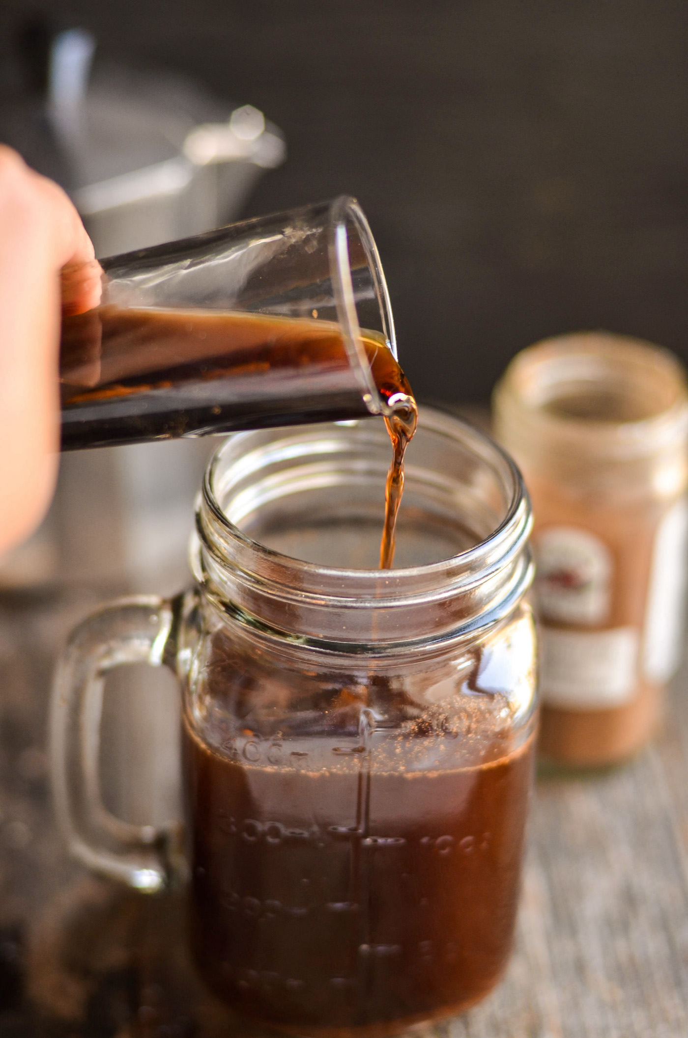 Pouring coffee into a mason jar glass mug