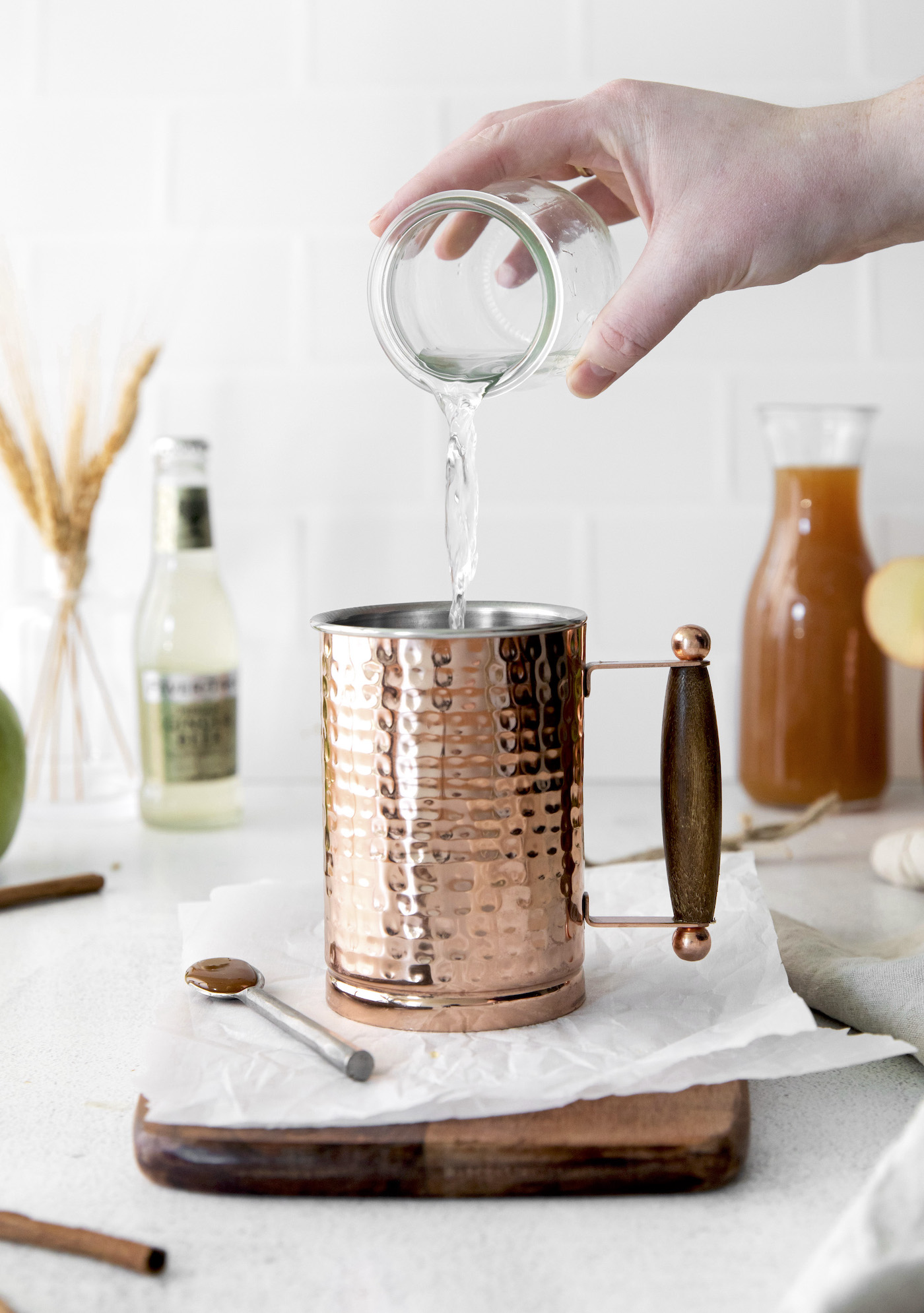 Pouring vodka into a metal mule cup