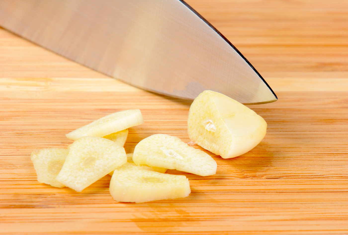 Slicing garlic with a knife on a cutting board