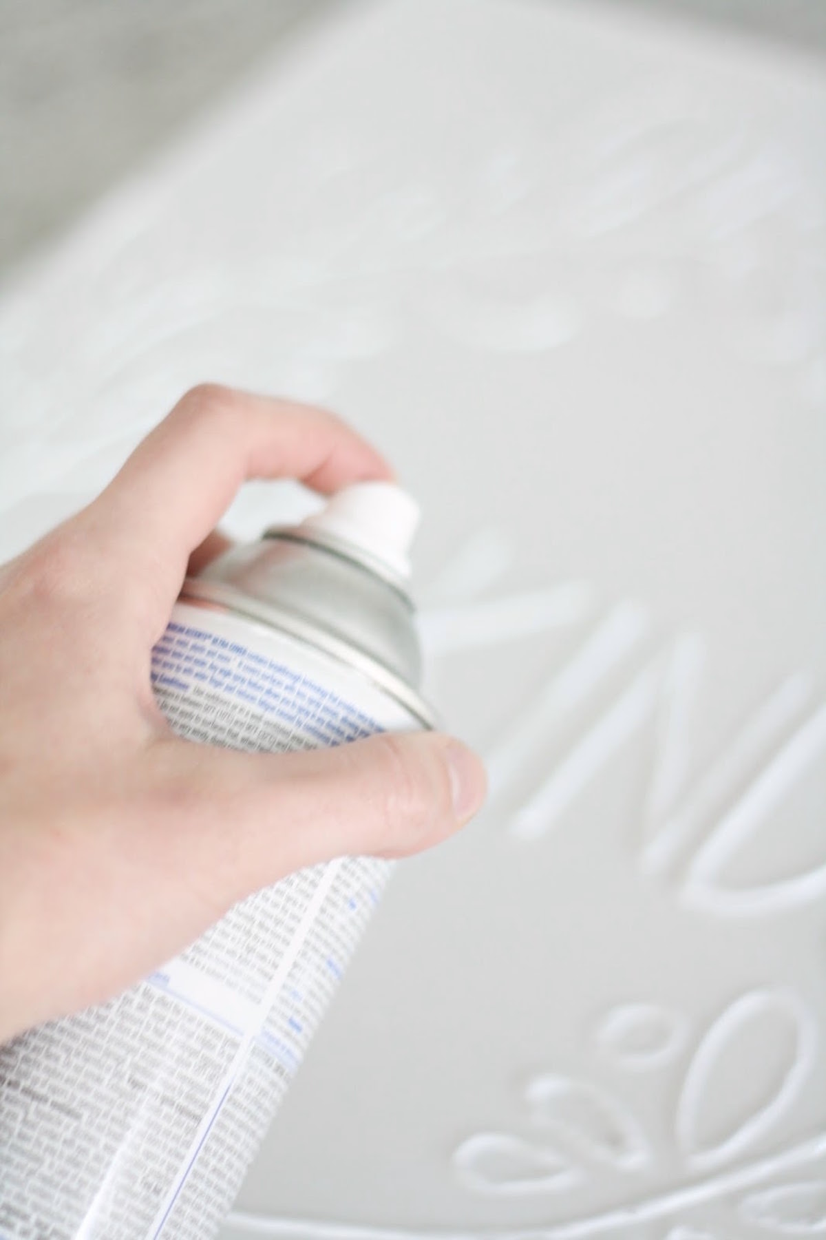 Spray painting the canvas with white spray paint