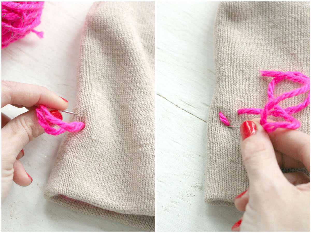 Stitching hearts into a tan beanie with neon pink yarn