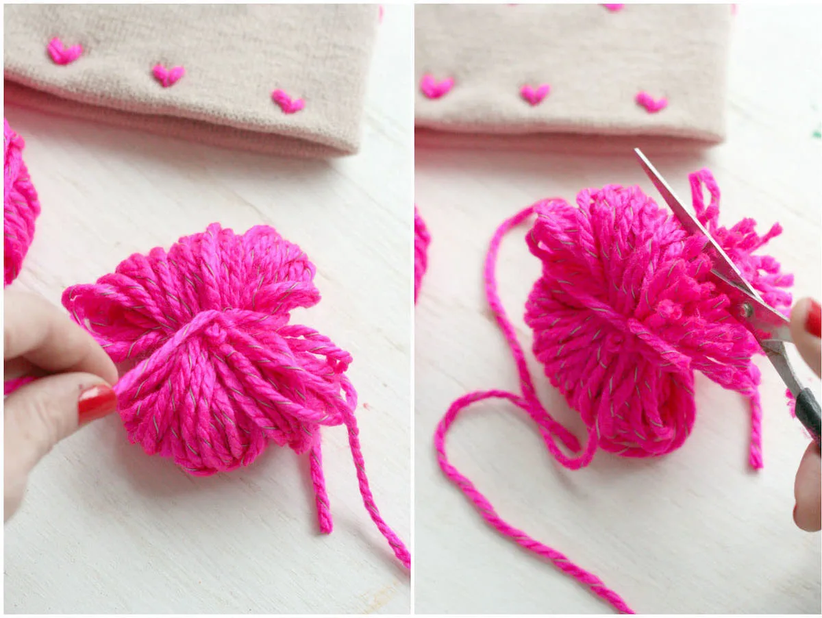 Tying a piece of yarn around wrapped yarn and cutting into a pom pom