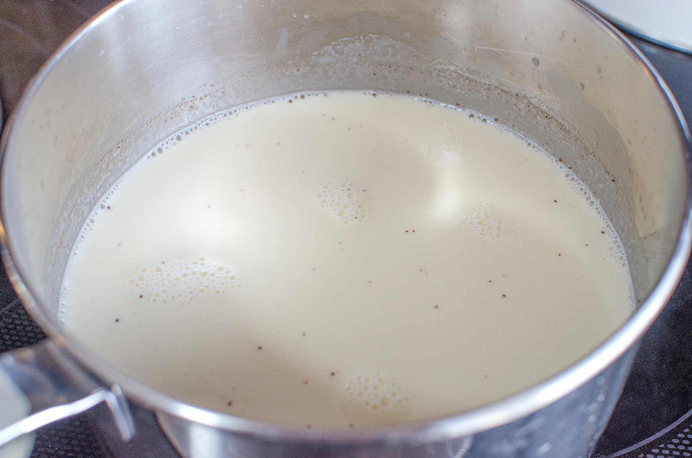 Whipping cream, eggnog, and half and half combined on the stove