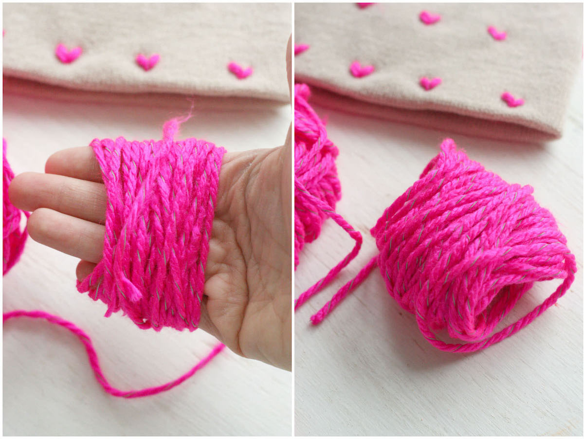 Yarn wrapped around a hand to make a pom pom